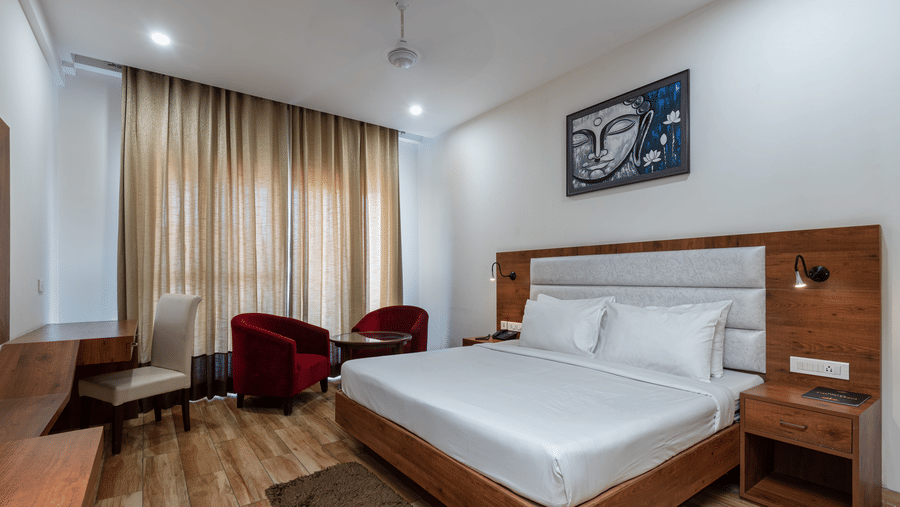 A Club Balcony Room featuring a bed, a teapoy and chairs at DLS The Classio